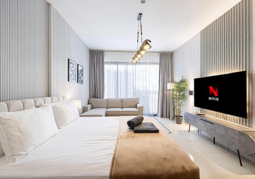 a living room with a large white couch and a tv at Apartment at Al Zahia - The Pearl in Ḩiz̧āyib az Zānah