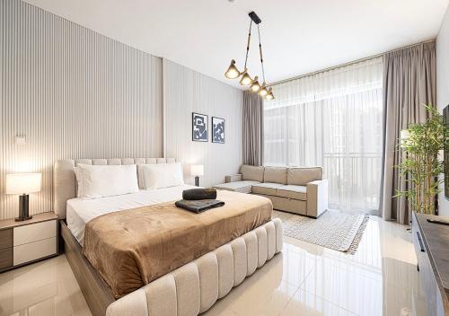 a bedroom with a large bed and a couch at Apartment at Al Zahia - The Pearl in Ḩiz̧āyib az Zānah