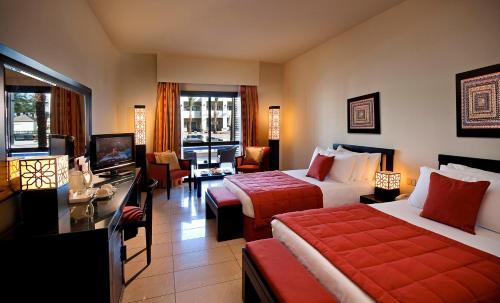 a hotel room with two beds and a television at Sentido Reef Oasis Aqua Park Resort in Sharm El Sheikh