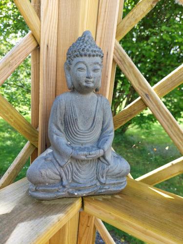 a stone statue sitting on a wooden structure at La Cressonnière 56 in Missiriac