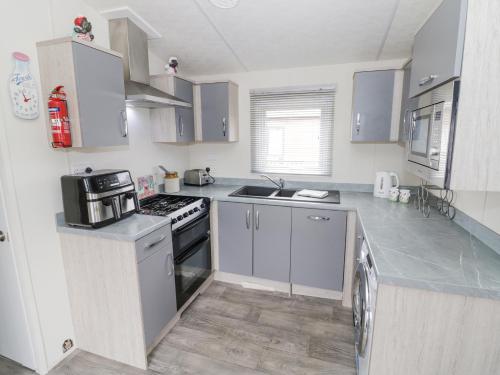 a kitchen with white cabinets and a stove top oven at Serenity in Evesham