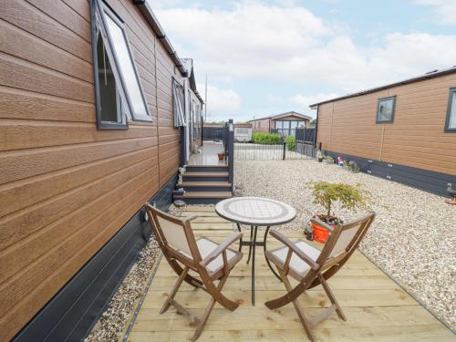 a patio with a table and chairs next to a building at Serenity in Evesham