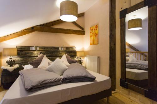 a bedroom with two beds and a large mirror at Domaine du Haut Jardin Hôtel & Chalets Spa Privé in Rehaupal