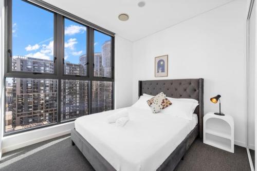 a bedroom with a white bed and large windows at High level Fabulous view 3Beds APT in WWP in Sydney