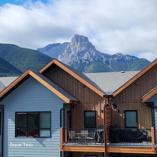 a couple of buildings with mountains in the background at Cozy Cove Retreat Escape to Tranquility Stay in Simplicity in Dead Man's Flats