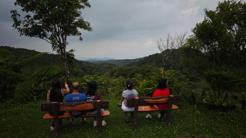 a group of people sitting on benches looking at the mountains at Highland Ridges in Real
