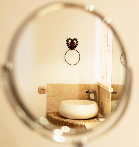 a bathroom with a round sink in a mirror at Domaine du Haut Jardin Hôtel & Chalets Spa Privé in Rehaupal