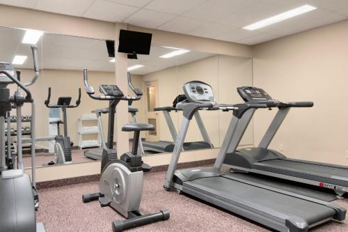 a gym with several tread machines in a room at Days Inn & Suites by Wyndham Thunder Bay in Thunder Bay