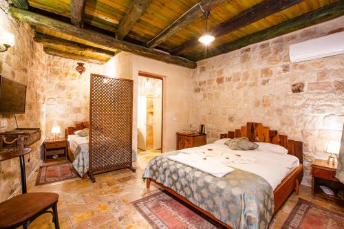 a bedroom with a bed and a mirror in it at kayadibi cave hotel in Ürgüp