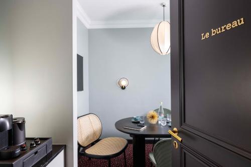 a room with a table and a small table with chairs at LE CLARK HOTEL in Paris
