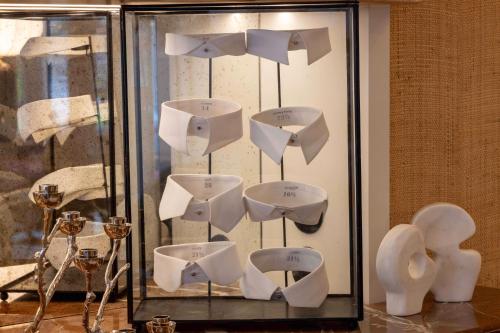 a display of white bowls in a glass case at LE CLARK HOTEL in Paris