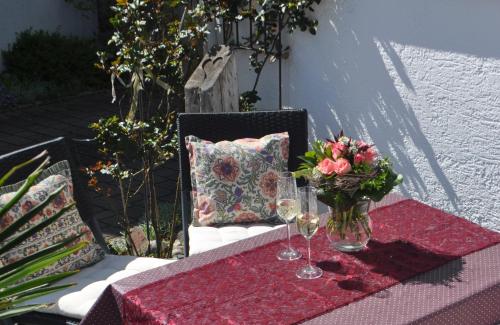 a table with wine glasses and a vase of flowers at Ferienwohnung Roth, Unlingen in Unlingen