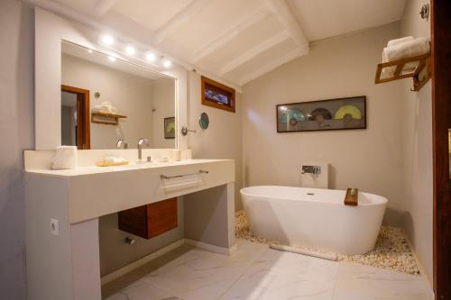 a bathroom with a tub and a sink and a bath tub at Pousada Mi Secreto in São Miguel do Gostoso