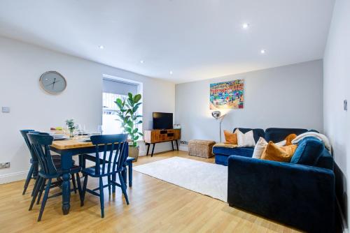 a living room with a blue couch and a table at Ethelbert Lodge - Arree Stays in Margate