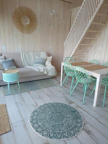 a living room with a couch and a table and chairs at Mazurskie Stodoły in Piecki
