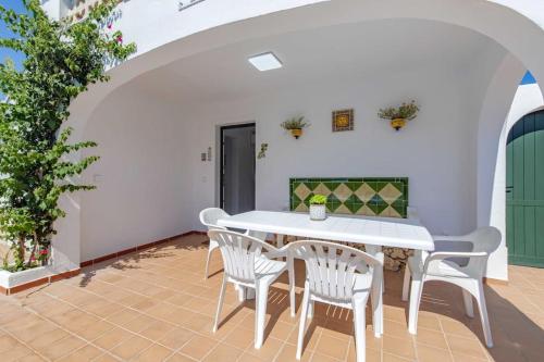 a dining room with a white table and chairs at Villa Mare a fabulous hideaway in S'Algar