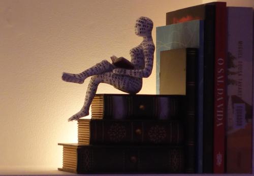 a doll sitting on top of a stack of books at HM - HouseMirage in Paço de Arcos