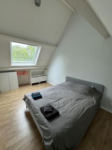 a bedroom with a bed with two towels on it at Maison familiale et cosy in Argenteuil