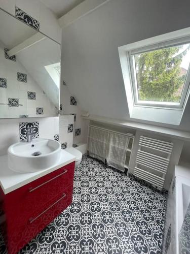 a bathroom with a sink and a toilet and a window at Maison familiale et cosy in Argenteuil