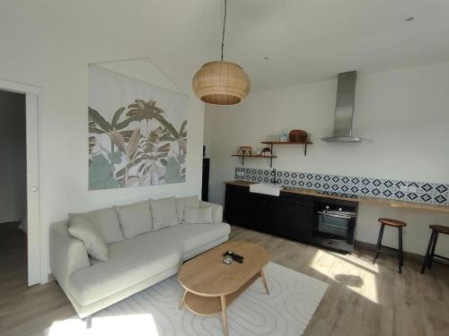 un salon avec un canapé blanc et une table dans l'établissement Maison cosy et élégante, à Cenon