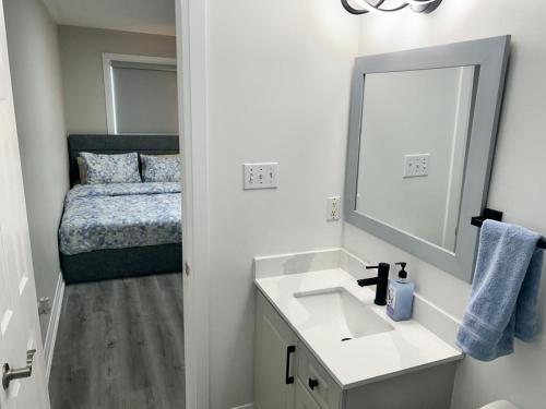 a bathroom with a sink and a mirror and a bed at Treasure Haven Near Tourism Barrie in Barrie
