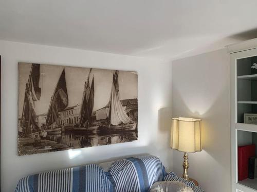 a living room with a painting of boats on the wall at Le Bodole in Viareggio