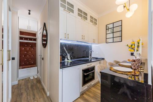 a kitchen with white cabinets and a black counter top at Новая дизайнерская квартира в Соломенском районе Киева in Kyiv