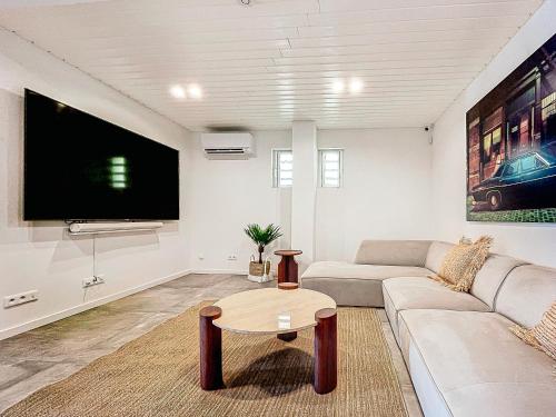 a living room with a couch and a tv at Mogador Beach House, luxury and uniqueness in Grand Case. in Grand Case
