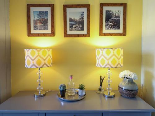 two lamps on a dresser in a room with a yellow wall at Hendre in Blaenau-Ffestiniog