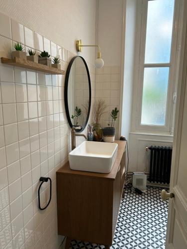 une salle de bain avec un lavabo et un miroir dans l'établissement Chambre double au 1 er étage, à Saint-Maixent-lʼÉcole