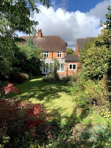 a large brick house with a grass yard in front at Town House, Stratford-upon-Avon in Stratford-upon-Avon