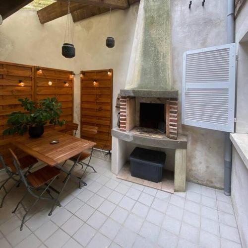 un patio avec une table et un four extérieur dans l'établissement Appartement charmant hypercentre avec patio privé et parking, à Orléans