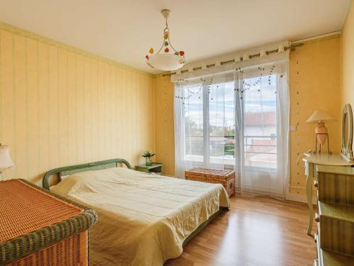 une chambre avec un lit et une grande fenêtre dans l'établissement Appartement cosy à Biarritz, proche des commerces et plages, avec parking et balcon - FR-1-3-607, à Biarritz