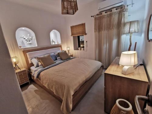 a bedroom with a large bed and a table at Skalani house avec jacuzzi in Skalánion