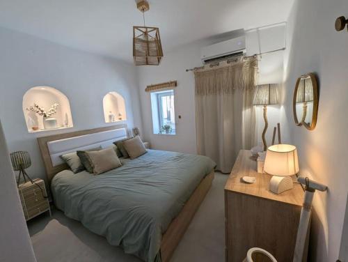 a bedroom with a bed and a table with a lamp at Skalani house avec jacuzzi in Skalánion