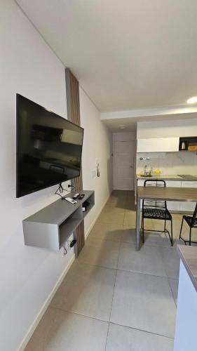 un salon avec une télévision à écran plat sur un mur dans l'établissement Alquiler Temporario Rosario 19, à Rosario