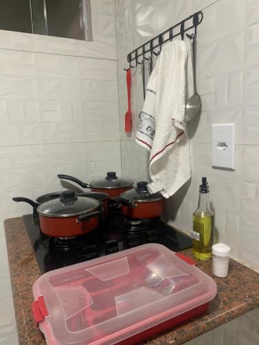 a kitchen counter with two pots on a stove at Residencial Estrela Guia 2 in Cabo Frio