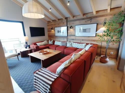 un salon avec un canapé rouge et une table dans l'établissement Chalet luxe avec jacuzzi, sauna, 8 ch, La Plagne Montalbert - FR-1-181-2718, à Hermillon