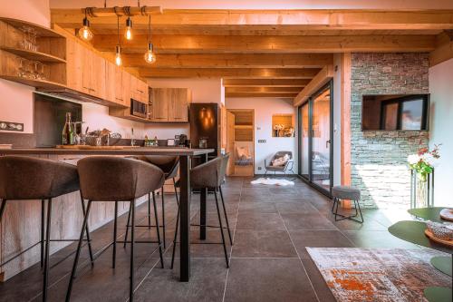 - une cuisine avec un bar et des chaises dans la chambre dans l'établissement Gîte de charme avec jacuzzi #Calme #Cosy, à Viuz-en-Sallaz