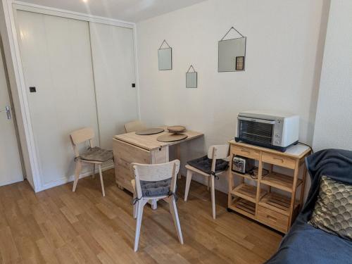 Cette chambre comprend un bureau avec un ordinateur et des chaises. dans l'établissement Appartement 5 pers. au pied des pistes avec balcon, lave-vaisselle, lave-linge - FR-1-557-133, à Les Adrets