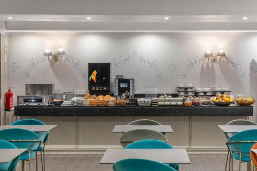 a restaurant with a counter with food on it at Hotel Madeira in Funchal