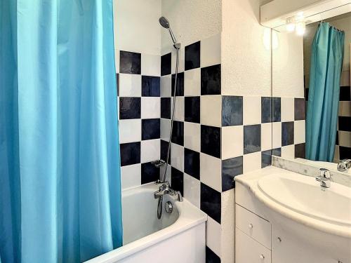 La salle de bains est pourvue d'un rideau de douche bleu et d'un lavabo. dans l'établissement T3 tout confort pour 6 pers. · Proche des pistes · Piscine chauffée · Navette gratuite - FR-1-267-276, à Villarembert