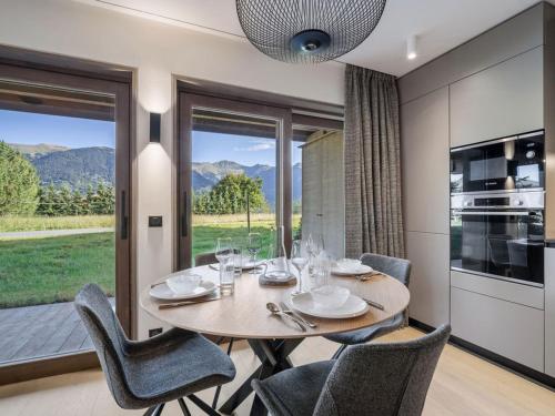 une salle à manger avec une table et des chaises et une fenêtre dans l'établissement Appartement moderne, proche des pistes avec 2 chambres, Wi-Fi et parking à Courchevel Le Praz - FR-1-568-50, à Courchevel