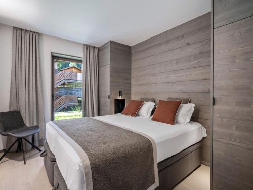 une chambre avec un grand lit et une fenêtre dans l'établissement Appartement moderne, proche des pistes avec 2 chambres, Wi-Fi et parking à Courchevel Le Praz - FR-1-568-50, à Courchevel
