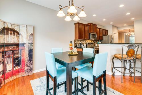 a kitchen and dining room with a black table and blue chairs at 3 Mi to Avalon Townhome with Balcony in Alpharetta! in Alpharetta