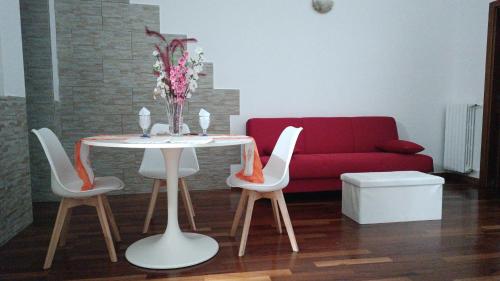 a living room with a table and a red couch at Principe Michelangelo in Bari