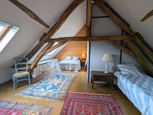 Camera mansardata con letto e sedia. di Havre de paix en Berry avec jardin et cheminée - FR-1-591-616 a Brives