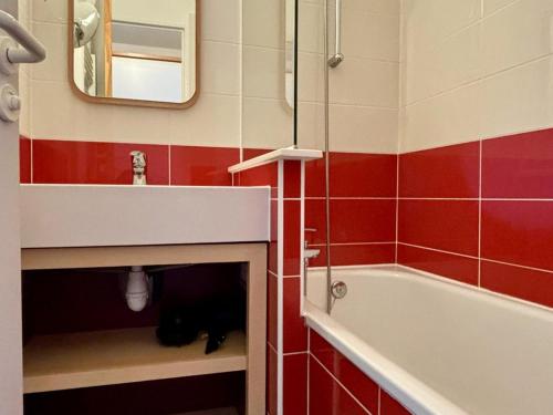 a bathroom with a sink and a black cat laying in the floor at Agréable 2 pièces avec balcon, internet, ménage et linge inclus - FR-1-634-102 in Morzine