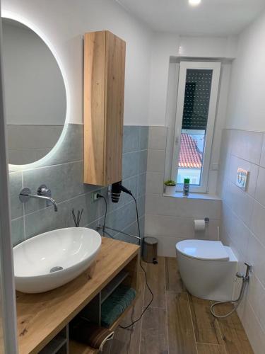 a bathroom with a white sink and a mirror at SoleMare Rooms Trieste in Trieste
