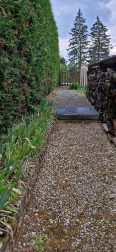 a stone path with a fence and some plants at L'Ain-parfait in Saint-Étienne-du-Bois